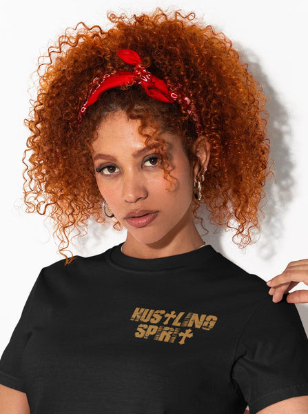 Woman wearing a black t-shirt with 'HUSTLING SPIRIT' text, sitting on a red chair against a white background.